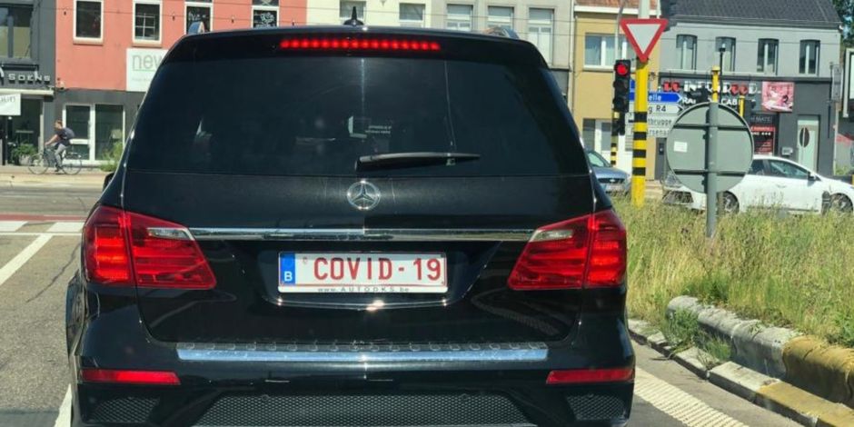 Photo de l'arrière d'une voiture stationnée dans un parking mettant la plaque d'immatriculation minéralogique "COVID-19" en évidence