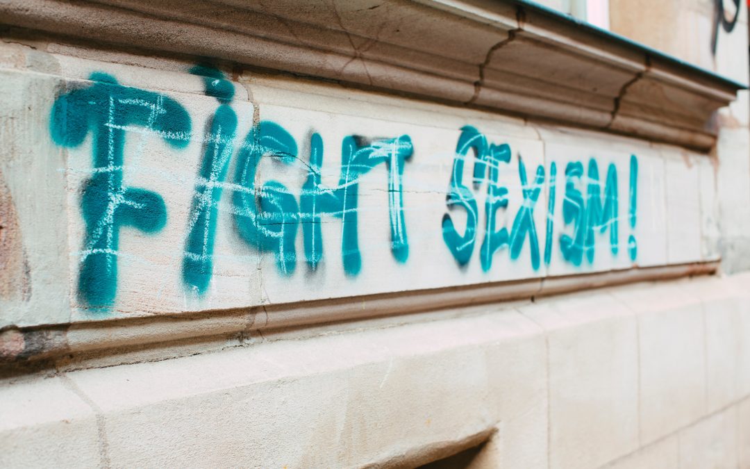 Photo d’un mur sur lequel est écrit en peinture verte « Fight sexism ! »